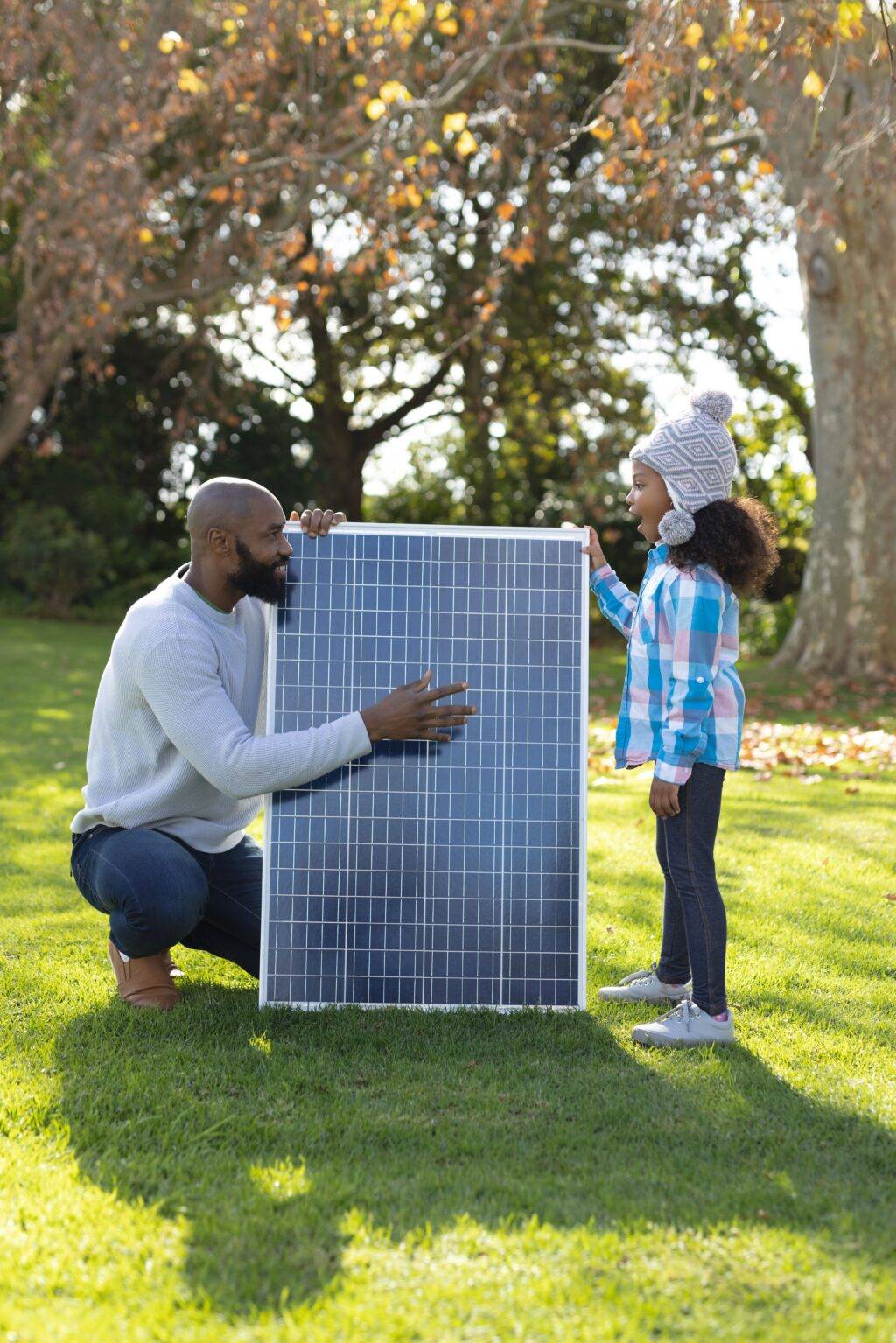 Father and daughter with a solar panel