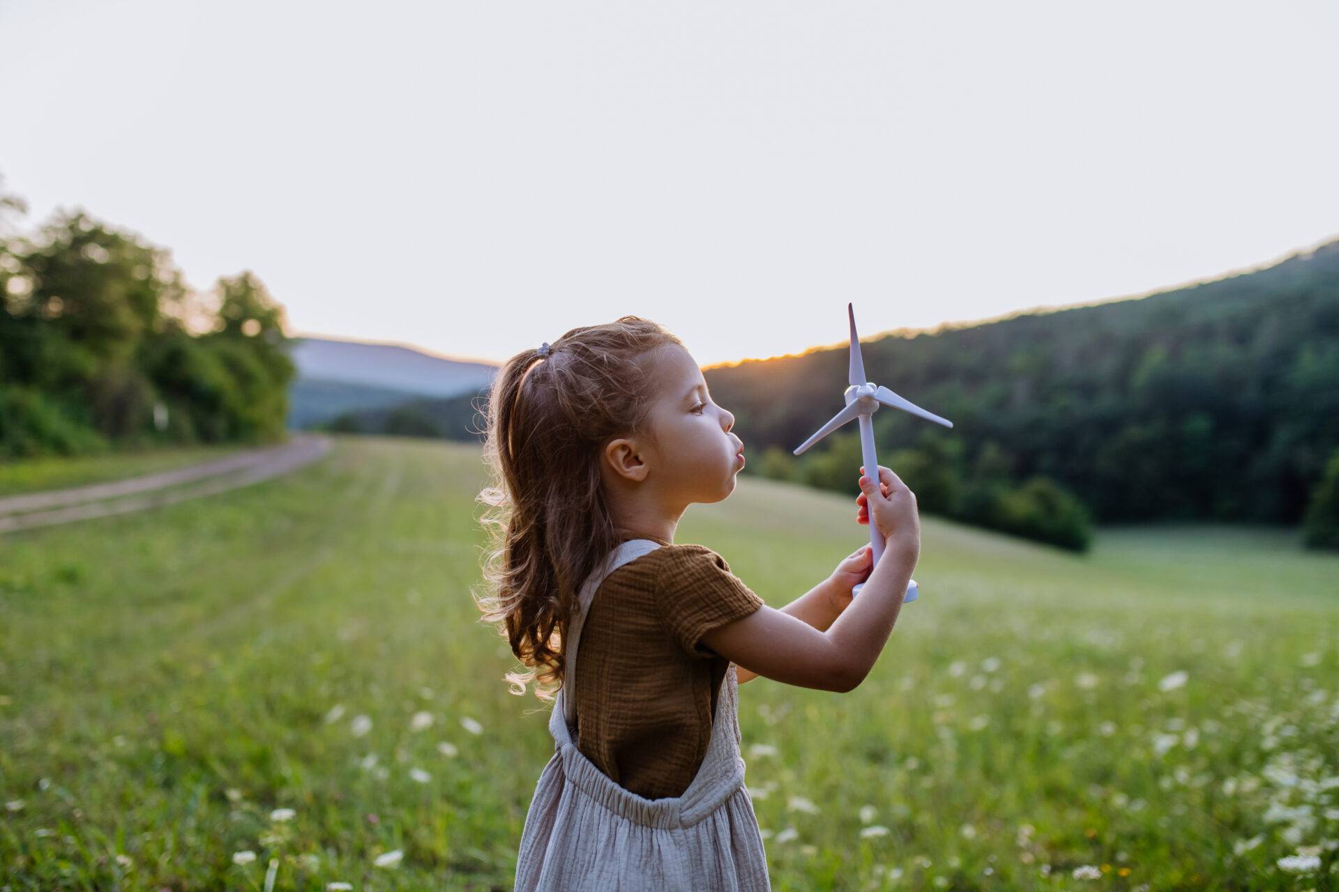 A little girl with a model of a wind turbine